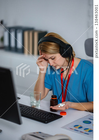 Stressed medical professional taking pills experiencing burnout Stressed medical professional taking pills experiencing burnout 138463001