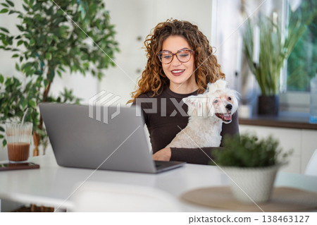 Woman working from home with pet dog on lap Woman working from home with pet dog on lap 138463127