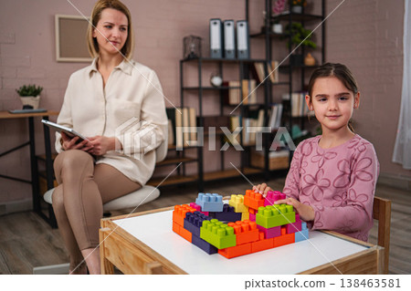 Child playing building blocks during elementary school psychologist session 138463581