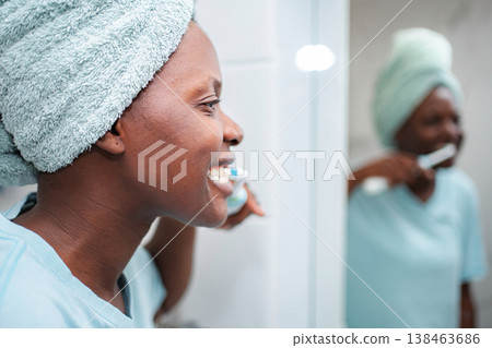 Smiling woman brushing teeth during morning hygiene routine Smiling woman brushing teeth during morning hygiene routine 138463686