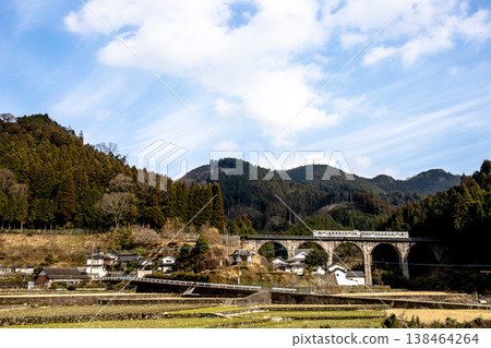 一列當地火車駛過一座石拱橋。 一列當地火車駛過一座石拱橋。 138464264