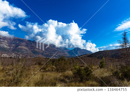 Majestic Mountain Landscape With Clear Blue Sky and White Clouds Over Quiet Valley 138464755