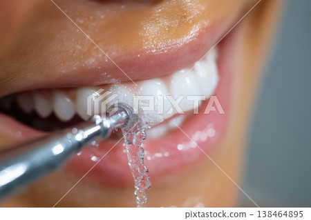 Macro shot of a dental irrigator cleaning between teeth 138464895