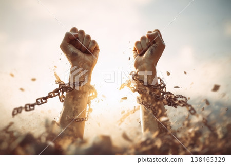 Hands raised break chains, freedom, empowerment and resilience concept shown in this conceptual stock material 138465329