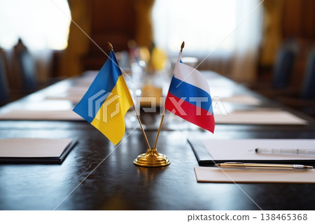Ukrainian and Russian flags stand on a table, symbolizing diplomacy and international relations during a meeting or negotiations. 138465368