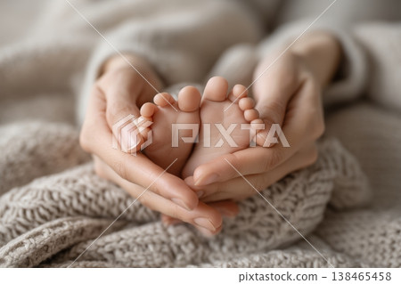 Tender moment as a mother gently cradles her newborn baby's delicate feet with love and care on soft blanket. Tender moment as a mother gently cradles her newborn baby's delicate feet with love and care on soft blanket. 138465458