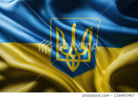 Ukraine flag texture displays the nation's blue and yellow colors alongside the national coat of arms, the Tryzub symbol. 138465467