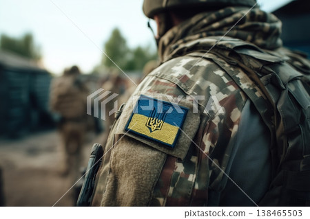 Soldier wearing camouflage uniform with the Ukrainian flag patch symbolizes strength and resilience during conflict Soldier wearing camouflage uniform with the Ukrainian flag patch symbolizes strength and resilience during conflict 138465503