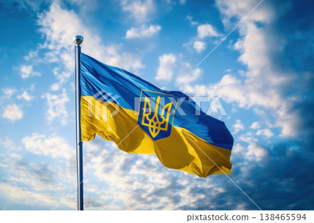 The national flag of Ukraine waves gently against a bright blue sky filled with fluffy white clouds, showcasing patriotism 138465594
