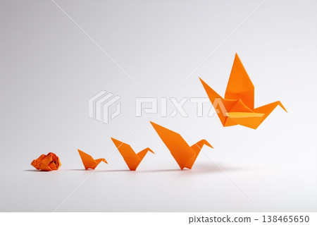 Orange origami cranes symbolize transformation, growth, and the journey of development on a plain background. Orange origami cranes symbolize transformation, growth, and the journey of development on a plain background. 138465650