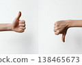 Approval and disapproval is shown with two hands, one with thumbs up, other with thumbs down on a clean white background. 138465673