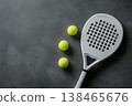 Get ready to play padel tennis with this modern racket and vibrant yellow balls on a dark background 138465676