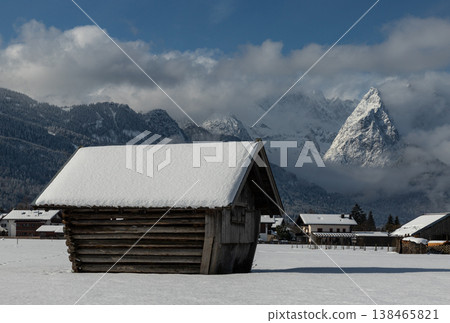 Wooden barn with snowy roof and striking alpine mountain in Bavarian winter landscape Wooden barn with snowy roof and striking alpine mountain in Bavarian winter landscape 138465821