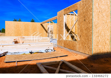 Workers assemble wooden walls beams frames at construction site during framework Workers assemble wooden walls beams frames at construction site during framework 138466272