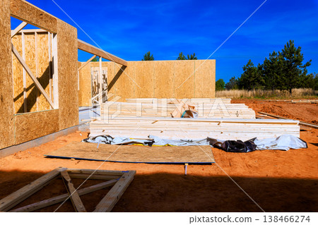 Workers are building structure using wooden beams frames plywood panels at site with framework Workers are building structure using wooden beams frames plywood panels at site with framework 138466274