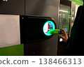 Man hand puts plastic bottle to the machine. Shoppers return their bottles and cans. High quality photo 138466313