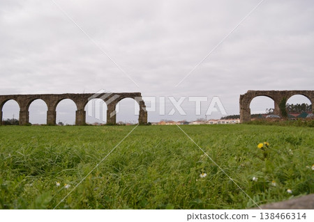 Part of a ruined ancient aqueduct in Portugal. Concept of historical values, architecture, and tourism. Part of a ruined ancient aqueduct in Portugal. Concept of historical values, architecture, and tourism. 138466314