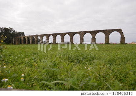 Part of a ruined ancient aqueduct in Portugal. Concept of historical values, architecture, and tourism. Part of a ruined ancient aqueduct in Portugal. Concept of historical values, architecture, and tourism. 138466315