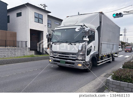 Medium-sized cargo truck driving through an urban area Medium-sized cargo truck driving through an urban area 138468133