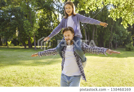 Happy little child boy sitting on fathers shoulders enjoying spending time together in summer park Happy little child boy sitting on fathers shoulders enjoying spending time together in summer park 138468169