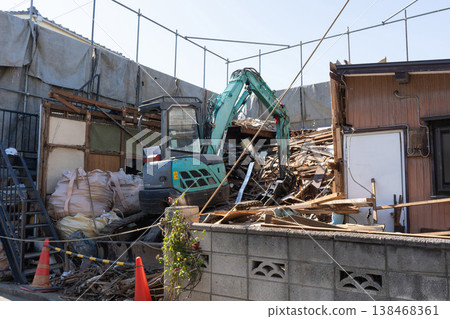 A scene from a house demolition project: heavy machinery is used to demolish a building (1). 138468361