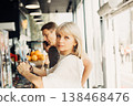 An adult mature happy couple in love in a street cafe order coffee. A blonde caucasian man and woman spend time together. Senior wife and husband walking outdoors. 138468476