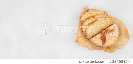 Sliced artisan sourdough bread on kraft paper over light background with copy space, top view 138468504