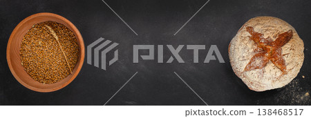 Artisan sourdough bread and wheat grains on dark background with copy space, top view 138468517