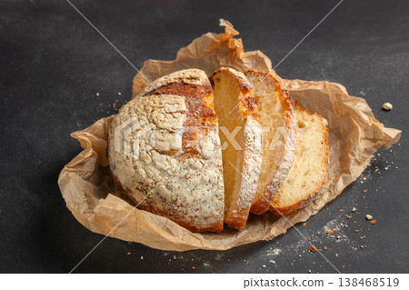 Sliced artisan sourdough bread loaf on kraft paper over dark background Sliced artisan sourdough bread loaf on kraft paper over dark background 138468519
