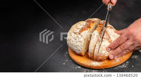 Slicing artisan sourdough bread into pieces on wooden board with copy space Slicing artisan sourdough bread into pieces on wooden board with copy space 138468520