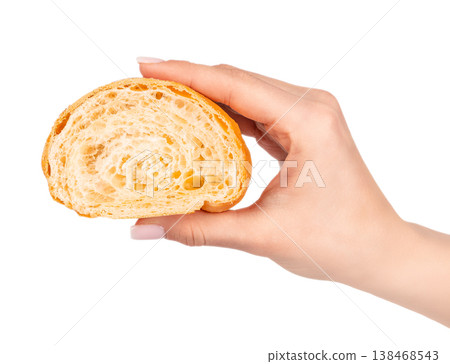 Woman hand holding croissant cross section showing airy texture isolated on light background Woman hand holding croissant cross section showing airy texture isolated on light background 138468543