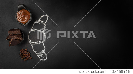 Chocolate spread, dark chocolate and coffee beans with croissant chalk drawing on black background, top view Chocolate spread, dark chocolate and coffee beans with croissant chalk drawing on black background, top view 138468546