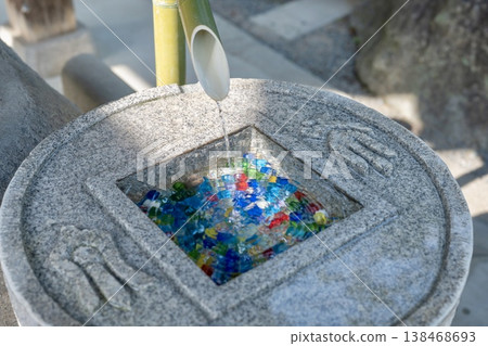 Water flowing from bamboo and colorful marbles Water flowing from bamboo and colorful marbles 138468693
