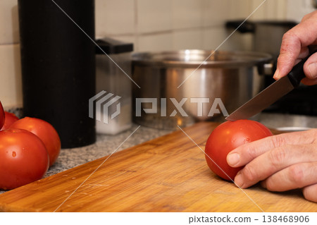 Scoring tomato with cross cut before cooking 138468906