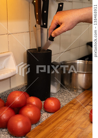 Man selecting chef knife from knife holder Man selecting chef knife from knife holder 138468911