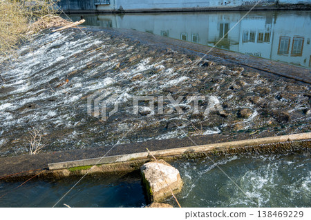 Rhein river in Bad Kreuznach in summer day. Nature landscape in little old city. River embankment in Germany with stones, house and trees. Rhein river in Bad Kreuznach in summer day. Nature landscape in little old city. River embankment in Germany with stones, house and trees. 138469229