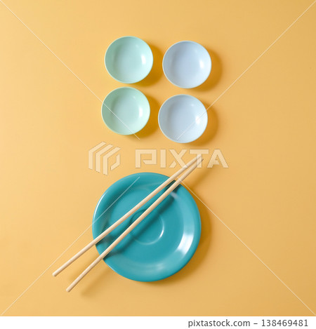 Plate and Chopsticks and small bowls on color background. Plate and Chopsticks and small bowls on color background. 138469481