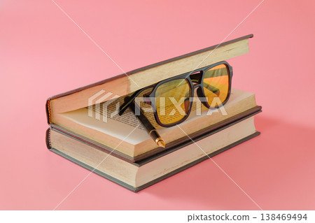 Eyeglasses inside open book on color background.knowledge and education theme. Eyeglasses inside open book on color background.knowledge and education theme. 138469494