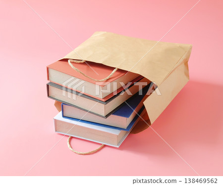 Books in paper shopping bag on color background. 138469562