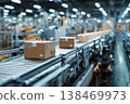 Sealed products travel along a conveyor belt in a factory. Workers manage the packaging process. The factory is busy with operations throughout the day 138469973