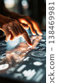 Hands interact with a touchscreen device showing detailed supply chain data and analytics in a bright, modern office space. The focus is on the fingertips and the screen 138469981