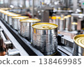In a canned food factory, blue jars move along a conveyor belt as they are processed. Workers monitor the line to ensure jars are filled and sealed correctly 138469985
