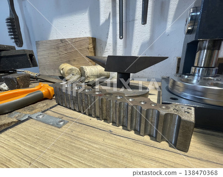 Metalworking tools and materials arranged on a workbench in a workshop during the day Metalworking tools and materials arranged on a workbench in a workshop during the day 138470368