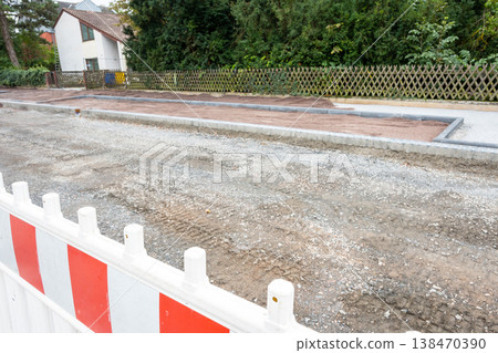 Pavement tiles for road sidewalk repair and bulldozer with backhoe. Construction process and urban infrastructure in big city in Germany. 138470390