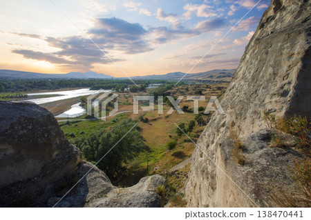 Cave city overlooking a river, with dramatic skies and mountains in Georgia Cave city overlooking a river, with dramatic skies and mountains in Georgia 138470441