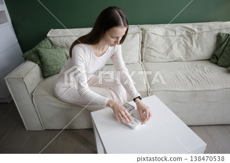 Brunette woman with white jewelry box in white and green interio 138470538