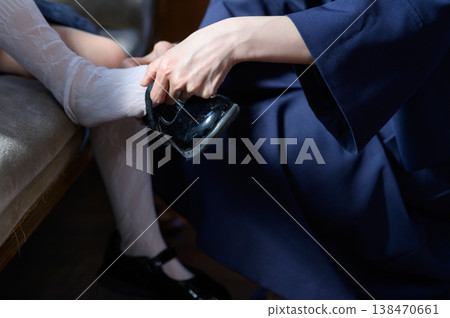 A Japanese mother putting shoes on her child. A Japanese mother putting shoes on her child. 138470661