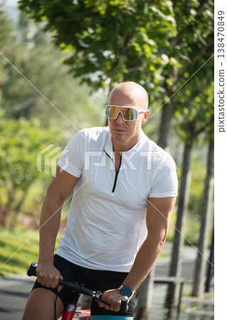 Athletic cyclist portrait in park wearing sunglasses Athletic cyclist portrait in park wearing sunglasses 138470849