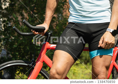Athletic man riding bicycle in green park Athletic man riding bicycle in green park 138470850