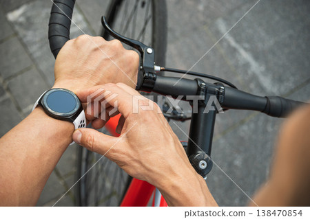 Athlete checking smartwatch during cycling workout Athlete checking smartwatch during cycling workout 138470854